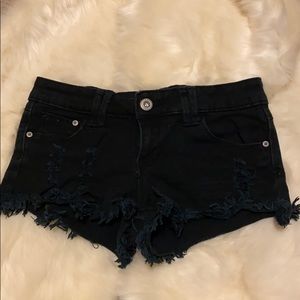 Distressed black denim short.